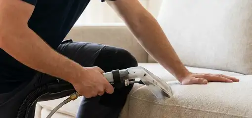 Professional upholstery cleaner deep-cleaning a fabric sofa with a handheld extraction tool, Marietta, GA.